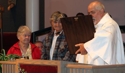  Rev. Elder Troy Perry, MCC Founder, presents a plaque to King of Peace MCC founding pastor Gloria Merrill at the church’s 30th Anniversary celebration.